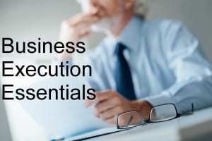 Pensive businessman with hand on chin looking away and holding a document, selective focus, glasses on foreground